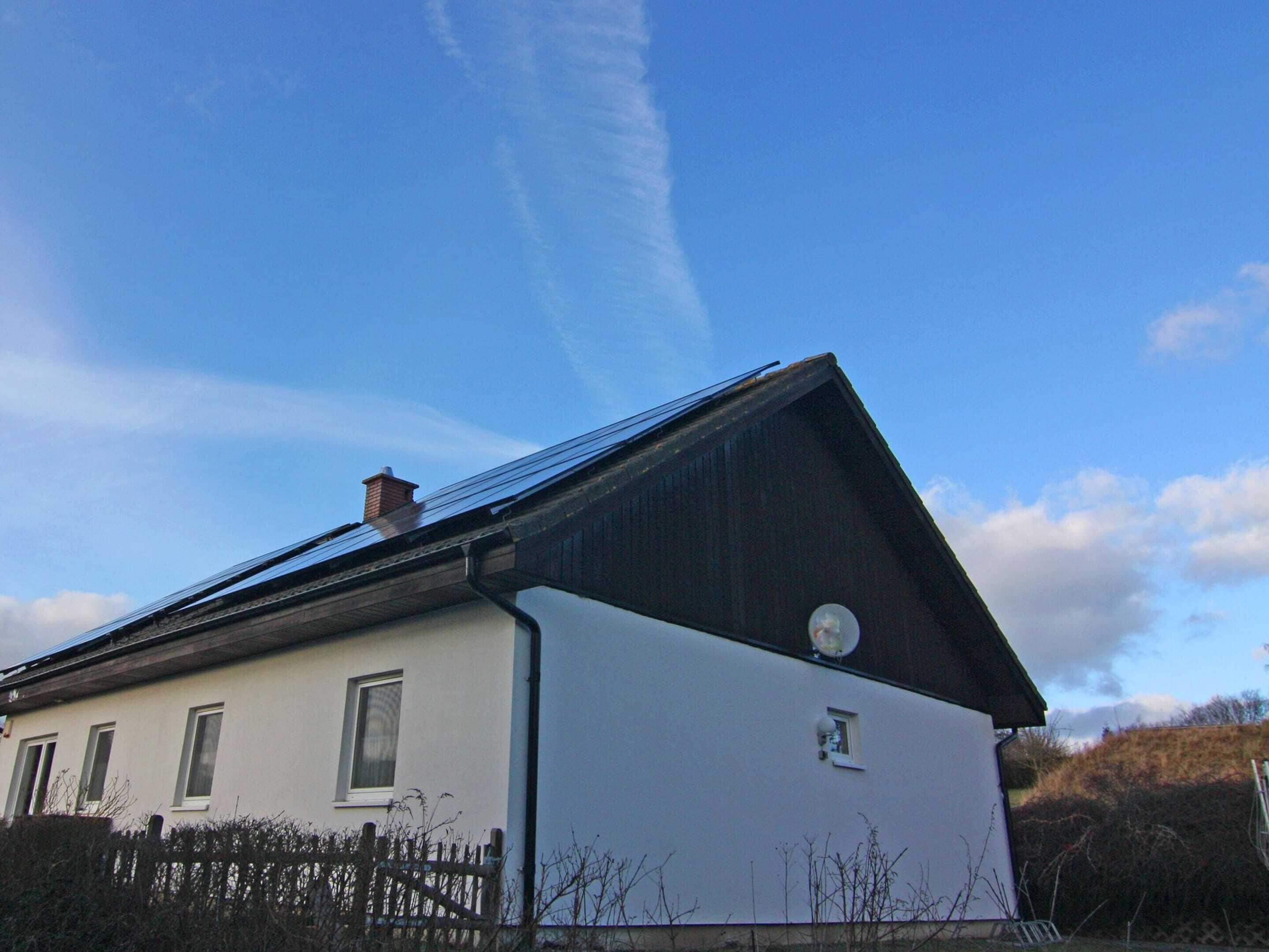 A house with a sloped roof, a satellite dish, and a small window.