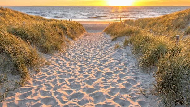 A sandy beach path leading to the ocean with a sunset in the background. - Semi-detached, Luxury Villa With 3 Bathrooms, sea at 400 m (De Koog)