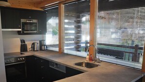 A modern kitchen with a built-in oven, a coffee maker, and a sink. - Luxurious Chalet With Sauna in Konigsleiten (Wald im Pinzgau)