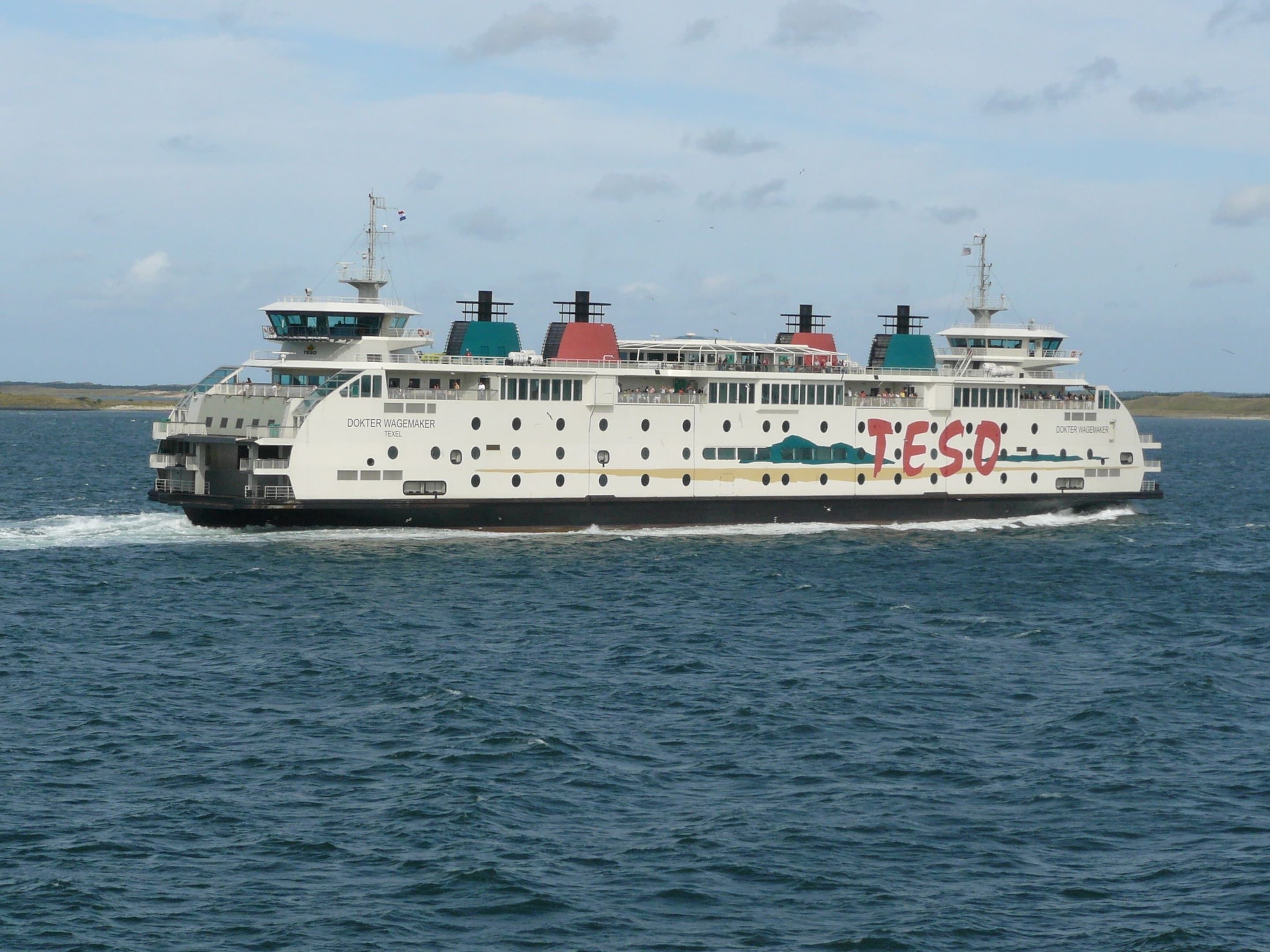 Un traversier portant l’inscription « TESO » sur sa coque, naviguant sur l’eau.