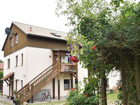 Un bâtiment à deux étages avec un escalier en bois menant à un balcon.