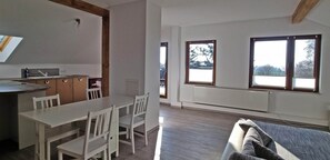 A modern kitchen with a dining area, large windows, and a built-in radiator. - Lovely Apartment in Rerik Near Baltic Sea Beach (Rerik)