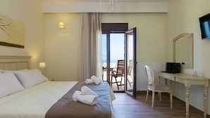 A hotel room with a bed, a desk with a laptop, a chair, a TV, and a view of the outdoors. - New Villa With Private Pool, Privacy, Near sea and Arkadi Monastery on NW Coast (Rethymno)