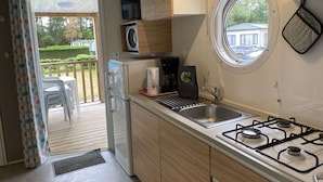 A compact kitchen with a built-in stove, a coffee maker, and a window. - Neat Chalet With Microwave, Antwerp at 39 km (Rijkevorsel)