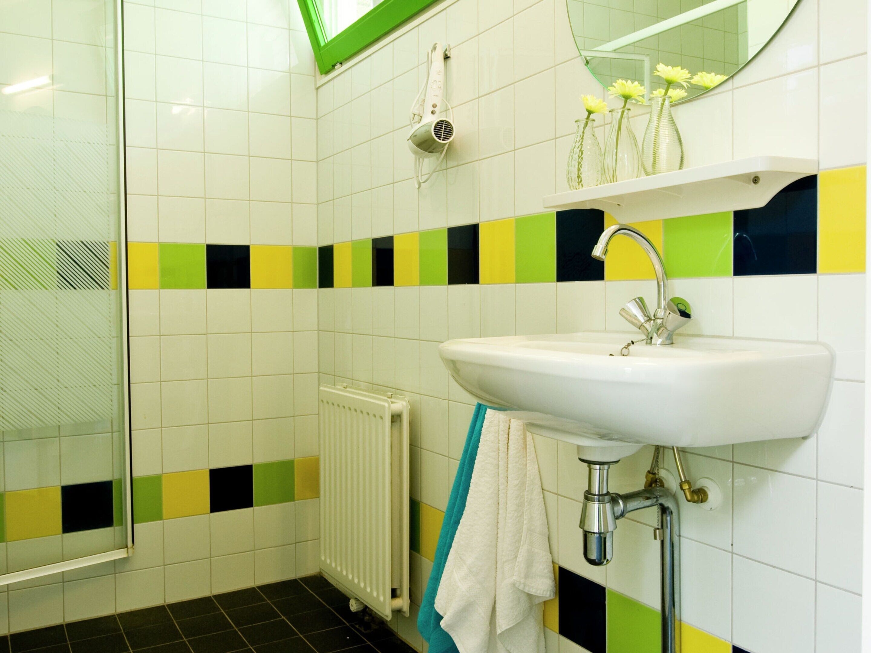 A bathroom with a white sink, a mirror, and a shower.