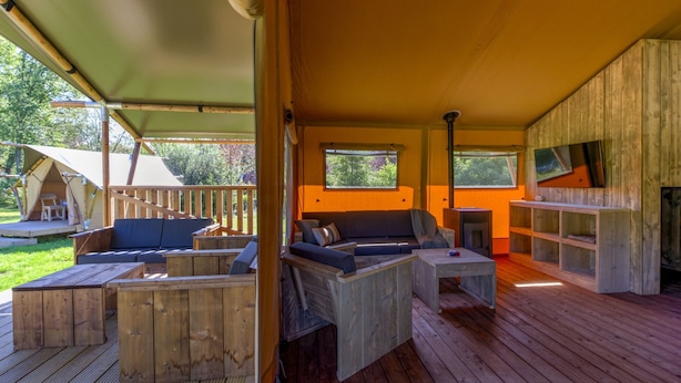 A wooden deck with outdoor seating, a fireplace, and a tent in the background. - Cozy Holiday Home With a Garden, Near Zwolle (Dalfsen)