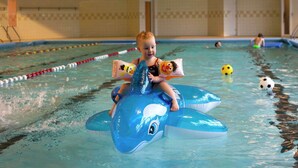 A child on a blue inflatable shark in a swimming pool with lane dividers. - Cozy Holiday Home With a Garden, Near Zwolle (Dalfsen)