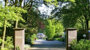 A pathway leading to a building with "Gerner" signs on either side, surrounded by lush greenery. - Cozy Holiday Home With a Garden, Near Zwolle (Dalfsen)