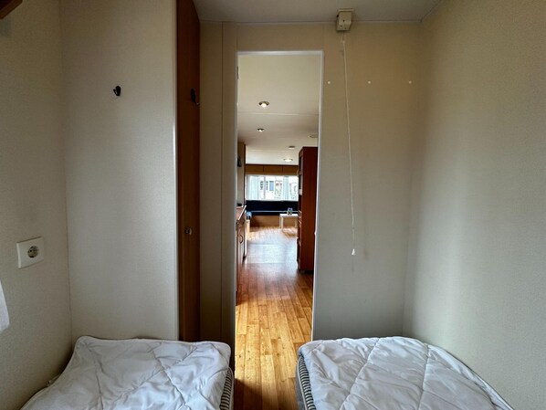 A narrow hallway leading to a kitchen with wooden flooring and a window. - Quaint Holiday Home in Overijssel With Spacious Garden (Heino)