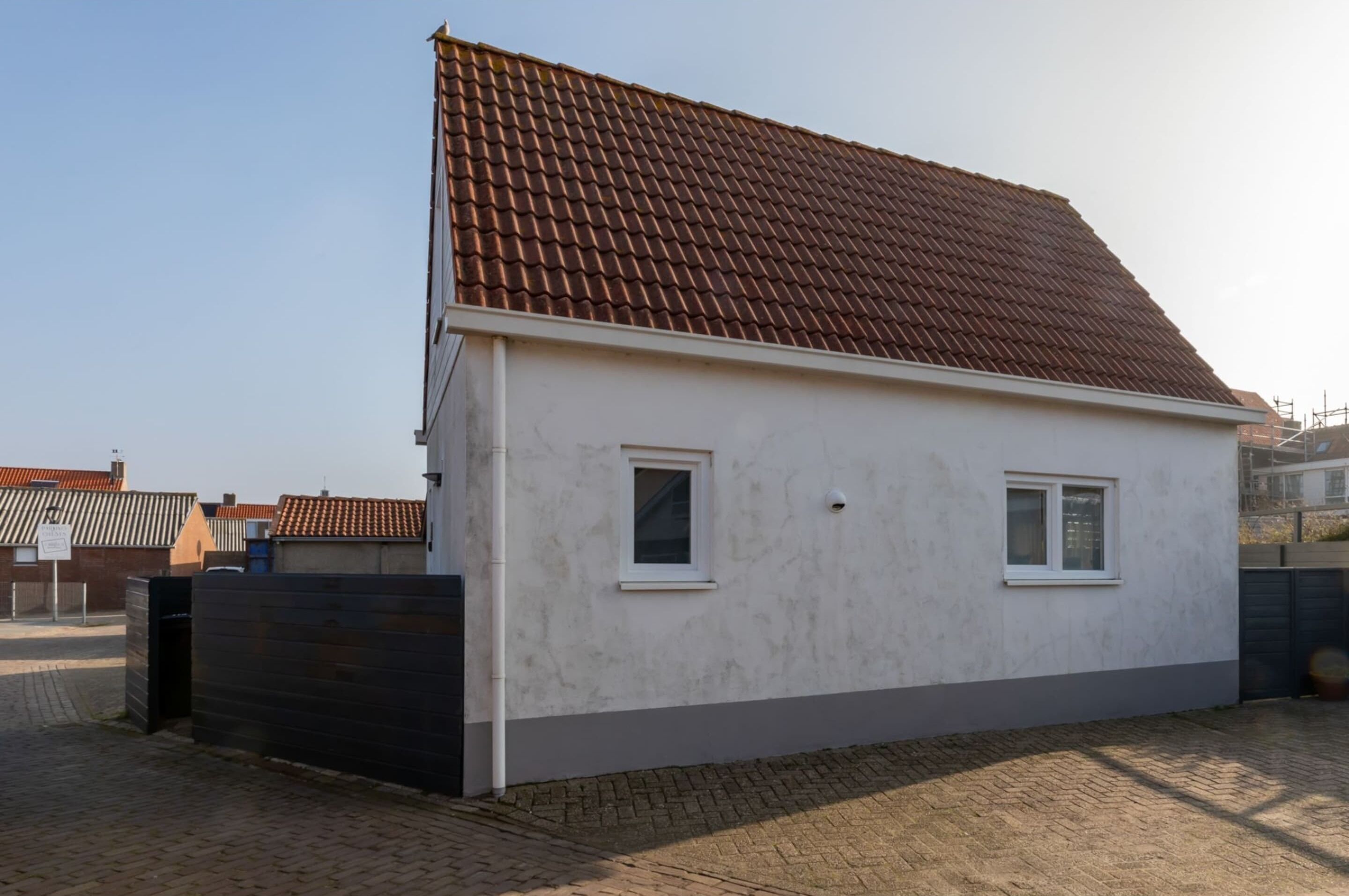 Ein kleines, eingeschossiges Haus mit einem Ziegeldach und zwei Fenstern.