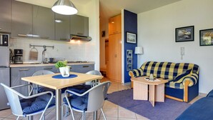 A compact living space with a kitchenette, a dining area with a table and chairs, and a sofa. - Airconditioned Studio Apartment With Seaview, not far From the Beach (Medulin)