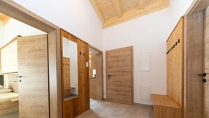 A modern interior with wooden doors and a bench. - Top Holiday Home in Kleinarl Near Cross-country Ski Trail (Kleinarl)