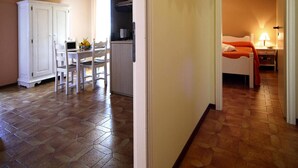 A compact living space with a dining area, kitchenette, and a bedroom. - Apartment in San Bartolomeo Al Mare (San Bartolomeo al Mare)
