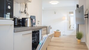 A modern kitchen with a built-in oven, a coffee maker, and a dishwasher. - Modern Flat in Neuastenberg With Balcony (Winterberg)