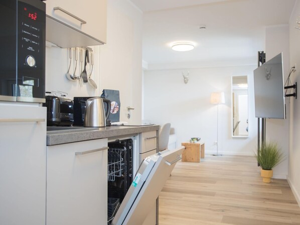 A modern kitchen with a built-in oven, a coffee maker, and a dishwasher. - Modern Flat in Neuastenberg With Balcony (Winterberg)