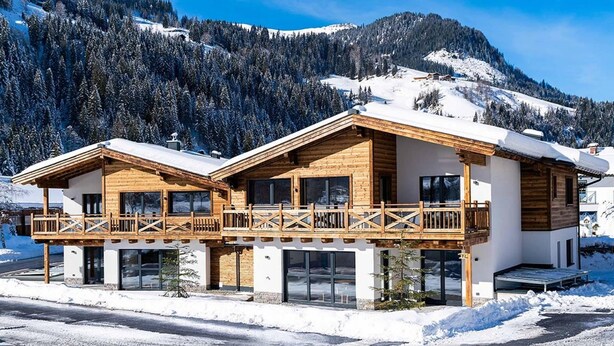 A two-story chalet with a wooden exterior, large windows, and a balcony. - Comfortable Holiday Home in Kleinarl With Garden (Kleinarl)