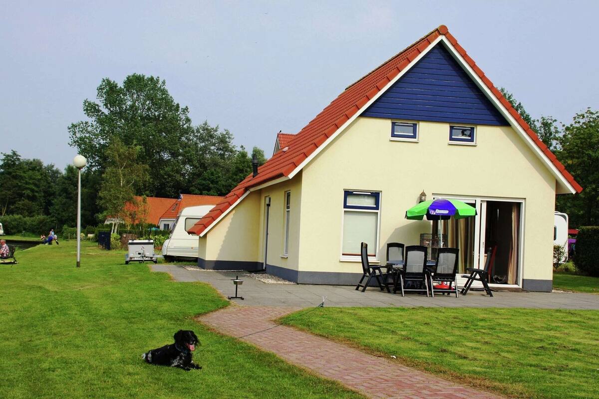 A house with a red roof and a small porch with outdoor seating.