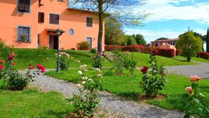 Una casa con giardino, rose e vialetto ghiaioso.