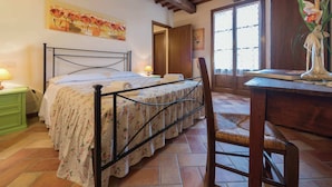 Una camera da letto con un letto, una scrivania, una sedia, una finestra e una porta.