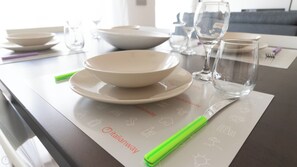 A dining table with bowls, glasses, and a knife on a placemat with icons. - Italianway Easy - Amedeo D'aosta 9 (Milan)