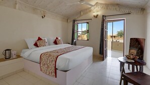 Een slaapkamer met een bed, een plafondventilator, een raam en uitzicht op buiten.