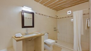 Een badkamer met een wastafel, spiegel, toilet en douche.