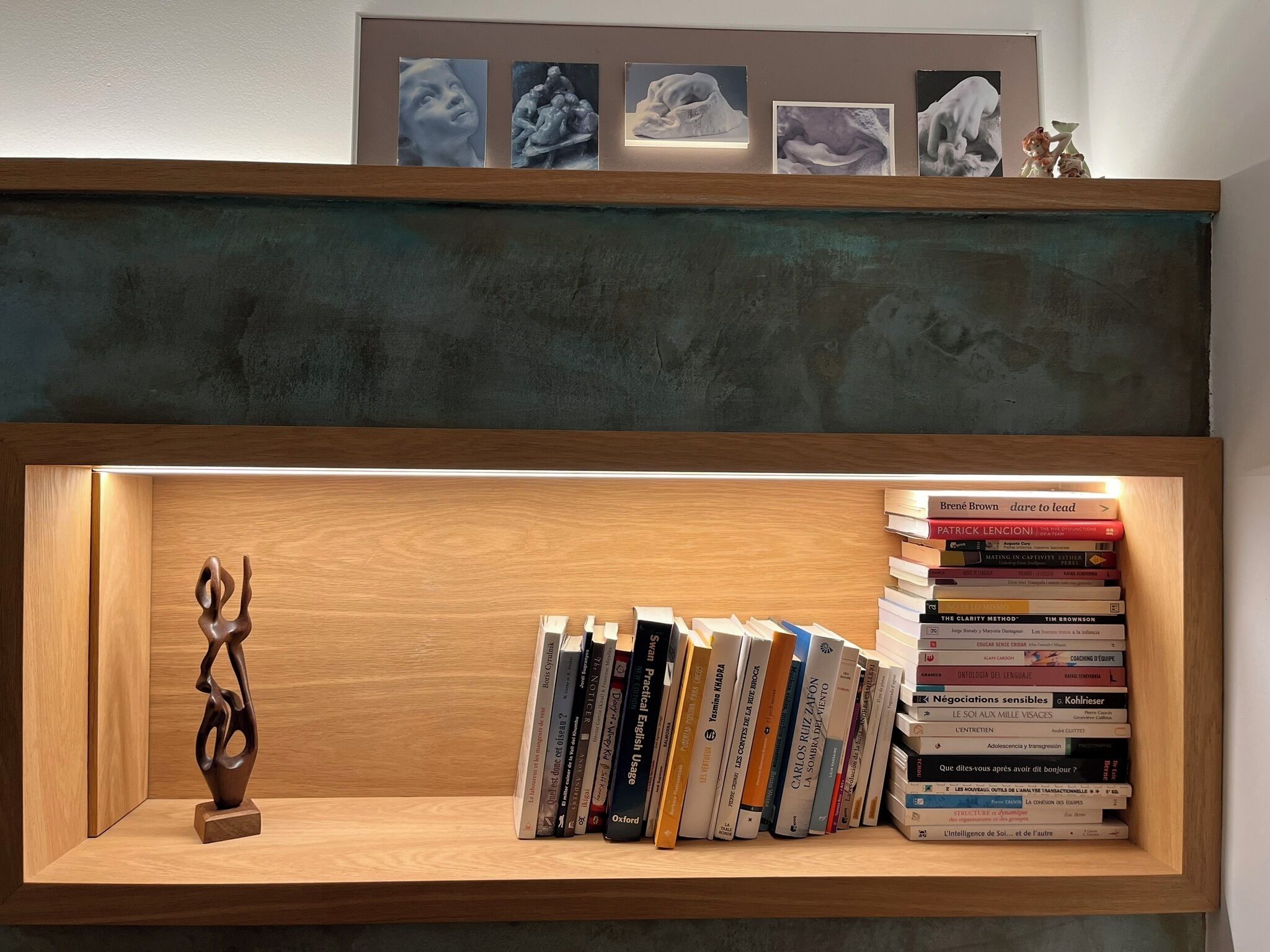Una estantería con una escultura y libros.