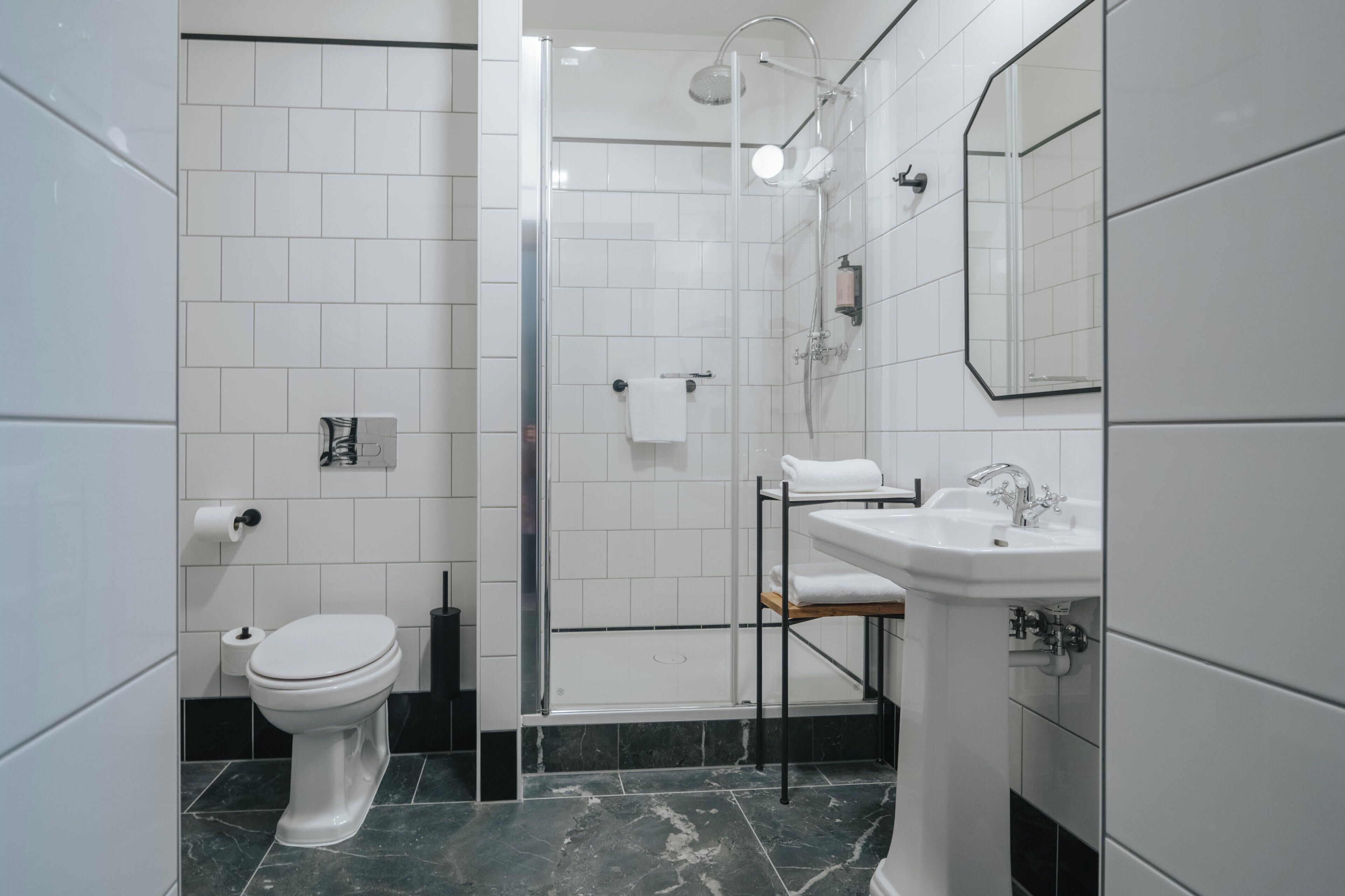 A modern bathroom with a toilet, a sink, and a shower area.