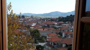 Vista desde una ventana sobre un pueblo con edificios de techo rojo y un muro de piedra.