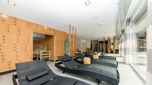 A modern spa area with black loungers, wooden walls, and a glass entrance. - Majestic Apartment in Klosterle With Sauna on the Arlberg Met Terras (Klösterle am Arlberg)