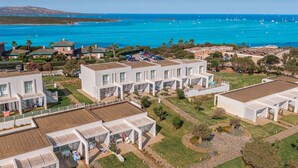 A coastal residential area with modern houses, a marina with boats, and a clear view of the ocean. - Residence Capo Falcone, Stintino (Stintino)