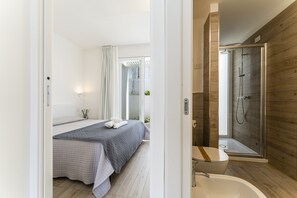 Un baño moderno con ducha acristalada, bañera y retrete a la vista.