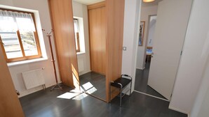 A modern interior with wooden flooring, a radiator, a standing lamp, and a hallway leading to another room. - Attractive Apartment in Rokytnice nad Jizerou Near Ski Area (Rokytnice nad Jizerou)