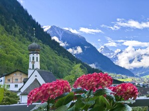 A mountain landscape with a church and houses in the foreground. - Beautiful Apartment in Gortipohl With Garden (Sankt Gallenkirch)