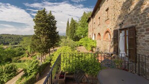 A stone building with a balcony overlooking a vineyard and a valley. - Attractive Apartment in Typical Tuscan Style (Figline e Incisa Valdarno)