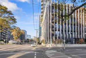 A modern building with a prominent vertical design, multiple balconies, and a clear sky. - Clarion Apartments South Melbourne (Melbourne)