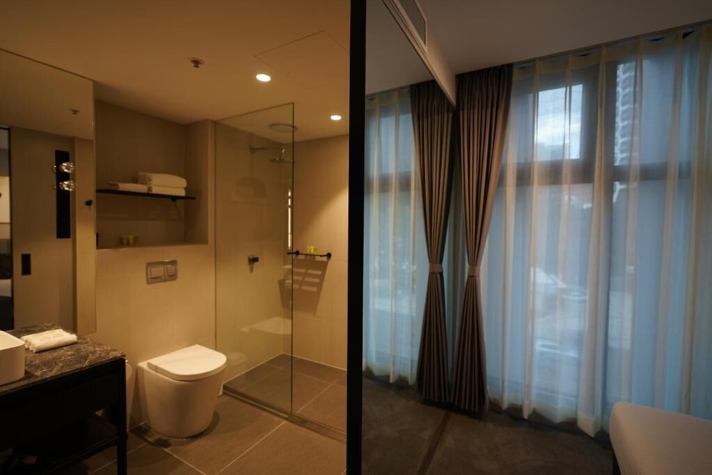 Ein modernes Badezimmer mit Duschkabine aus Glas, Toilette und Waschtisch mit Spiegel.