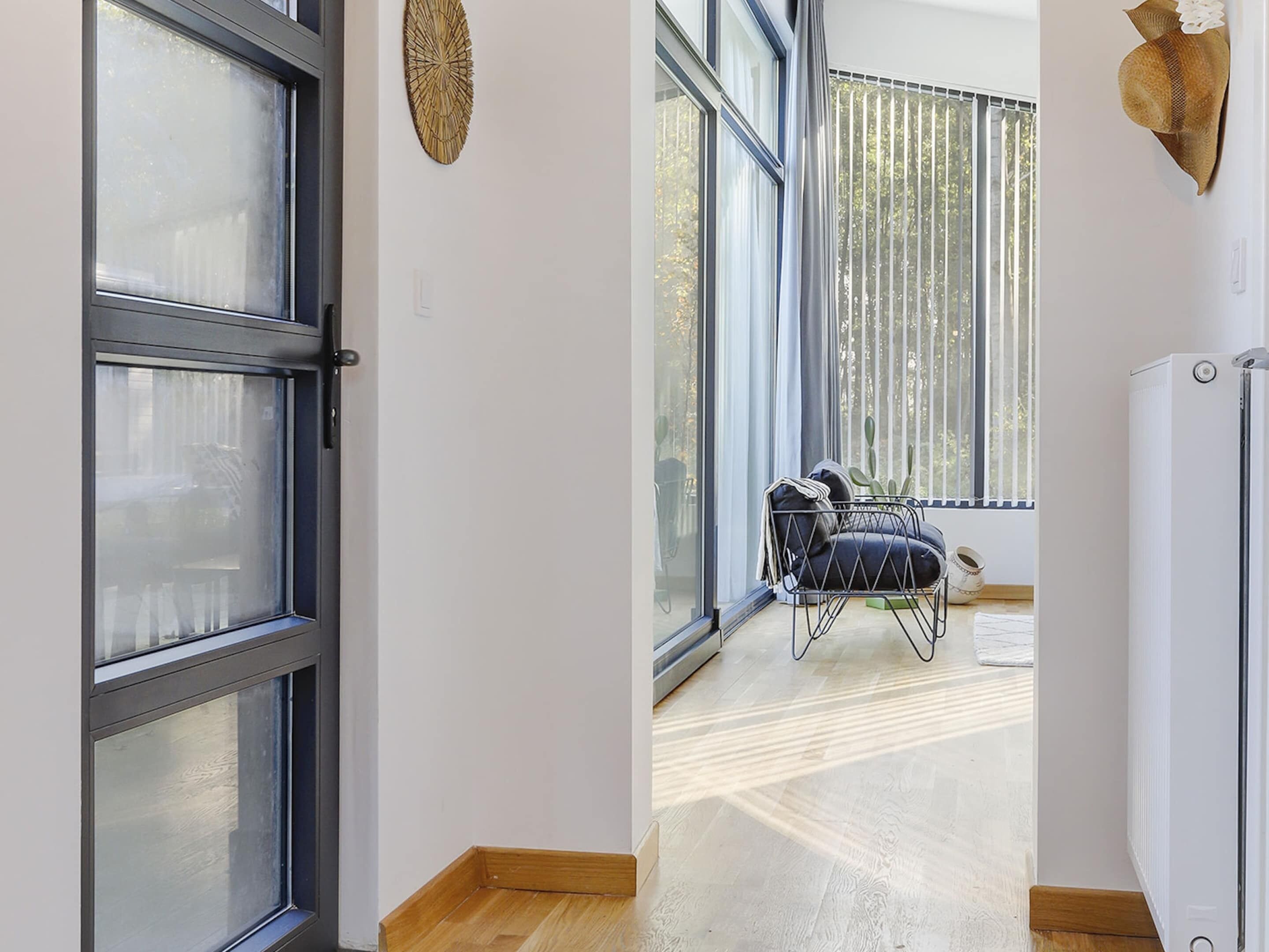A modern room with large windows, a chair with cushions, and a small table.
