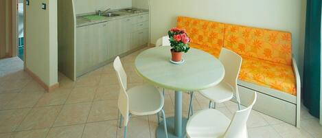 A compact living space with a kitchen, dining area, and a sofa.
