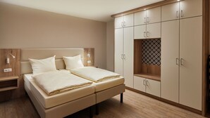 Ein Schlafzimmer mit Bett, Nachttischen, einem Kleiderschrank und einem Beistelltisch.