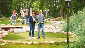 Ein Golfplatz mit Putting Green, umgeben von Felsen und Grünpflanzen.