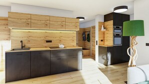 Een moderne keuken met houten kastjes, een inbouwoven en een opvallende groene hanglamp.