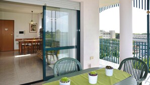A balcony with a table, chairs, and potted plants. - Apartment in the Residence Delle Terme in Bibione Spiaggia (San Michele al Tagliamento)