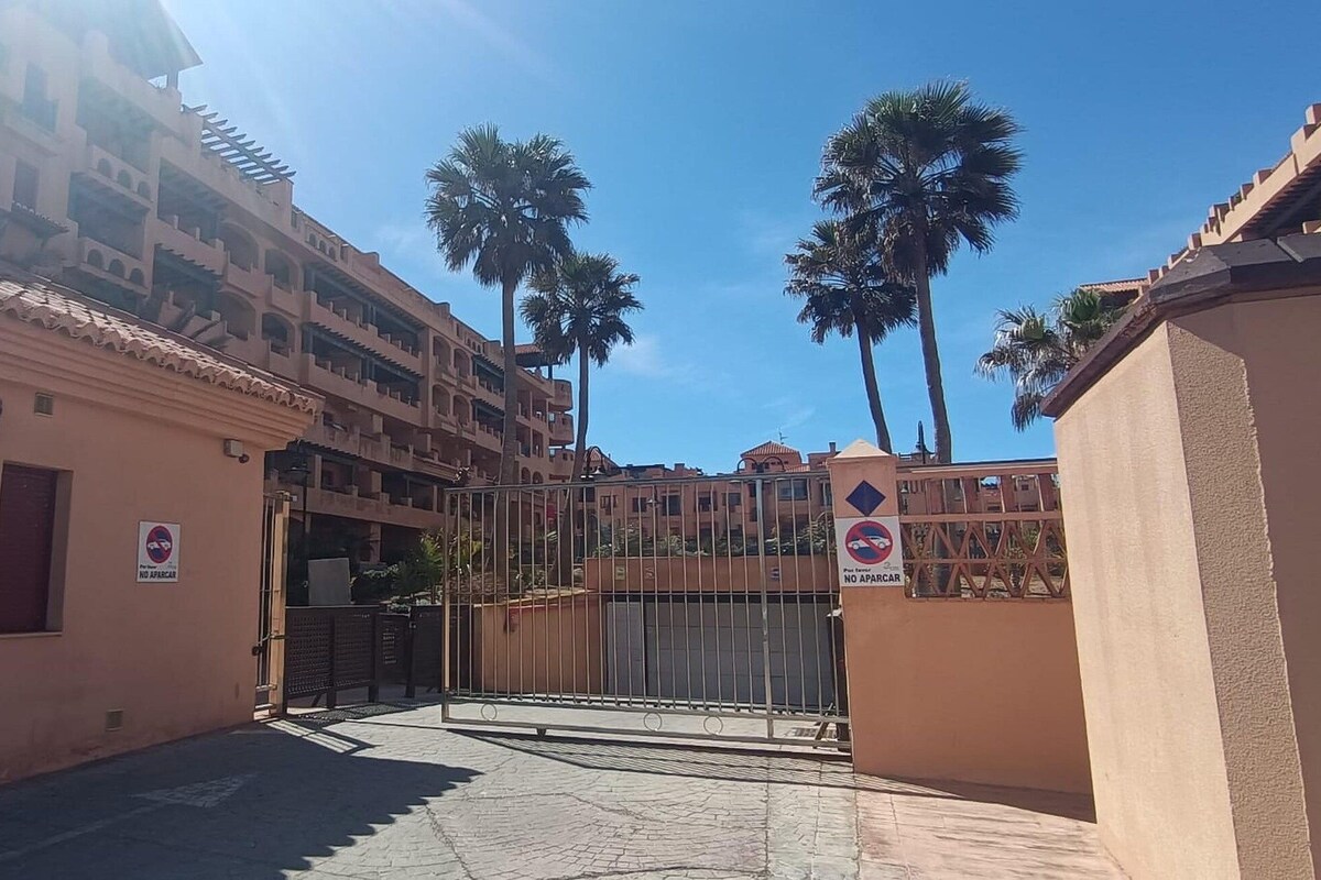 Une entrée fermée par un portail mène à un immeuble résidentiel, et une plaque indique : « Spirit Mar Residential ».