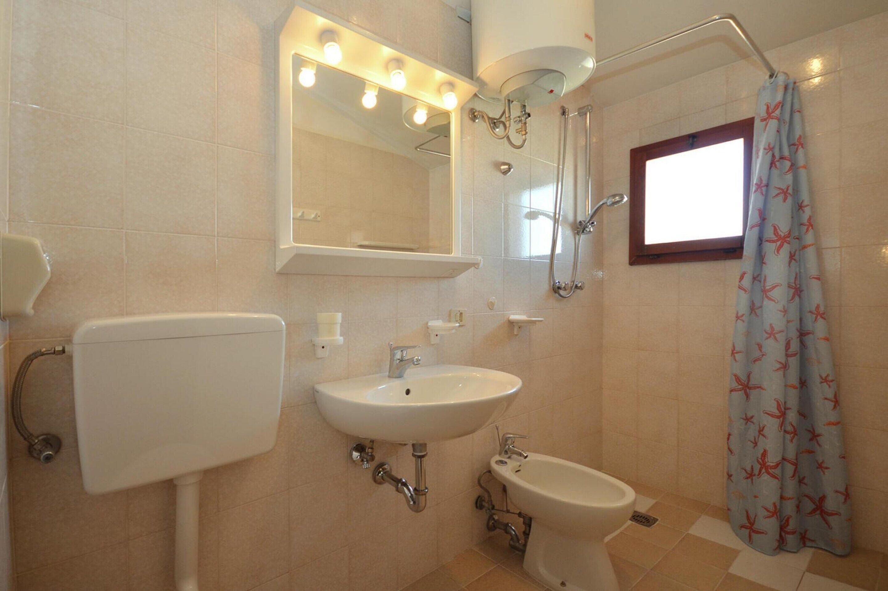 Ein Badezimmer mit Toilette, Waschbecken, Bidet und Dusche.