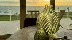 A room with a large window overlooking a beach at sunset. - Luxury Apartment in a Residence Right on the Boulevard and the Beach (Egmond aan Zee)