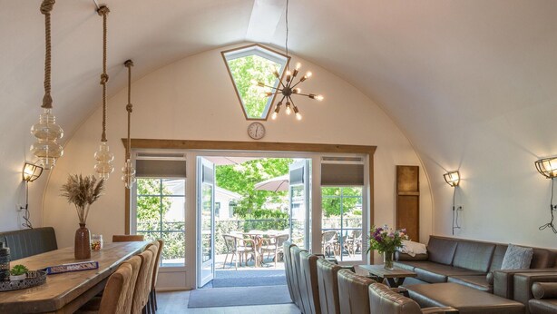Un comedor acogedor y bien iluminado, con techos altos y vistas al patio exterior.