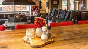 Un rincón interior acogedor con chimenea, sofás cómodos y una mesa de madera con adornos.