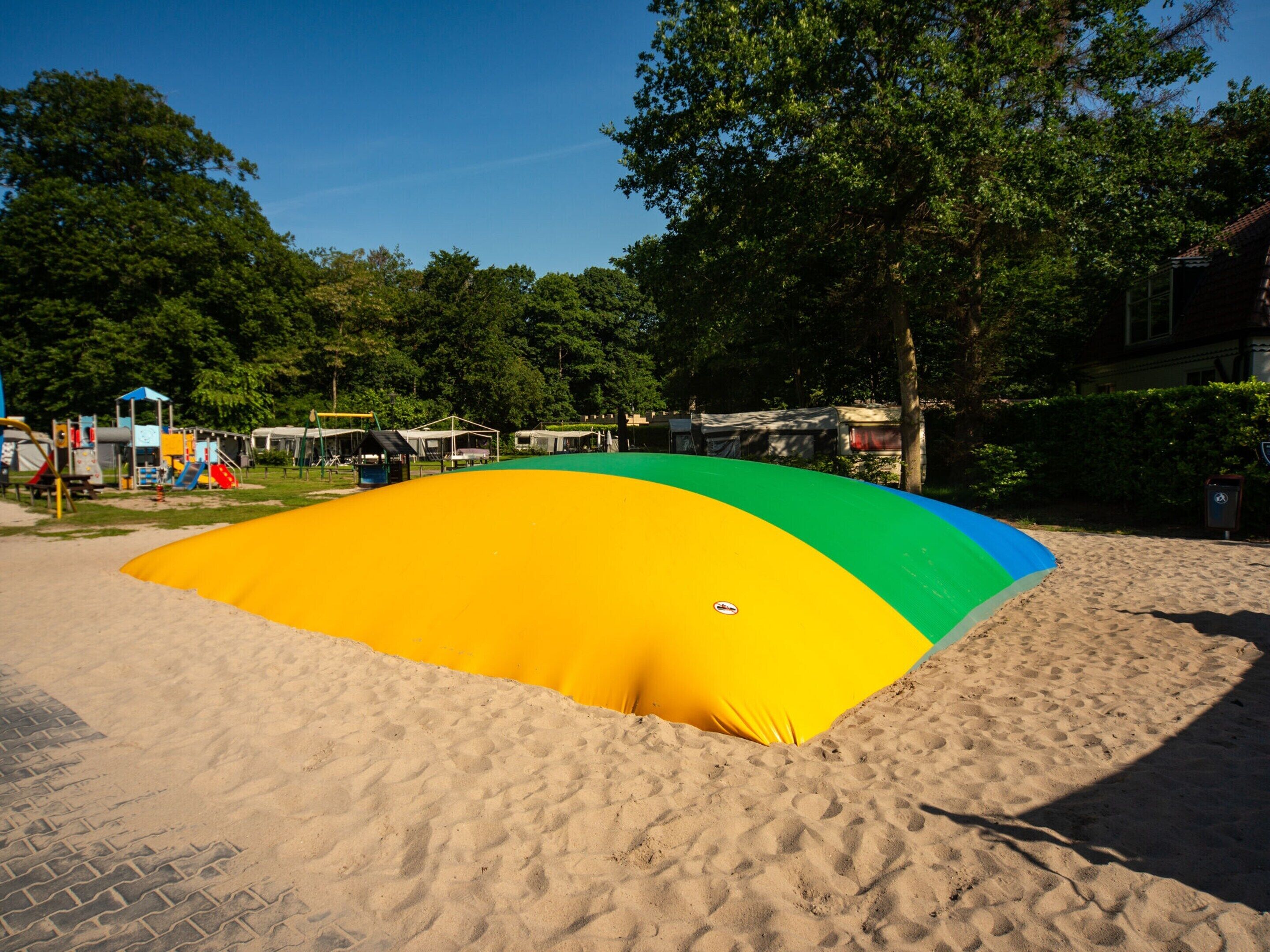 A sandy beach area with a colorful inflatable structure.