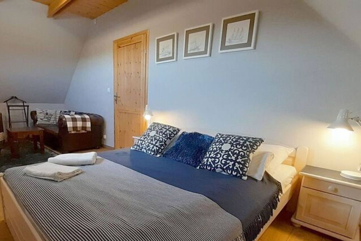 A bedroom with a bed, bedside tables, a chair, and a wardrobe.